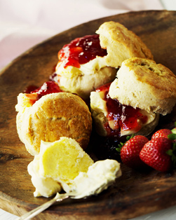 Bij een traditionele afternoon tea horen scones: kleine ronde cakejes die je eet met clotted cream (een soort dikke, geklopte room) en strawberry preserve (aardbeienjam).