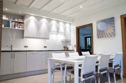 Moderne keuken met lakafwerking en strakke lichthemel geplaatst in een bestaand klassiek huis (35jaar oud). Er is wel gekozen voor klassieke kaderpanelen met een vlak paneel, wat een goede mix geeft als aansluiting bij de rest van het interieur.